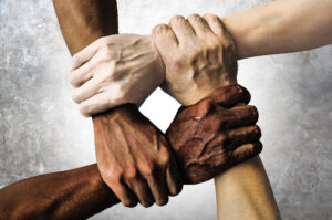 Employment Discrimination Lawyer Tampa, FL - multiracial group with black african American Caucasian and Asian hands holding each other wrist in tolerance unity love and anti racism concept