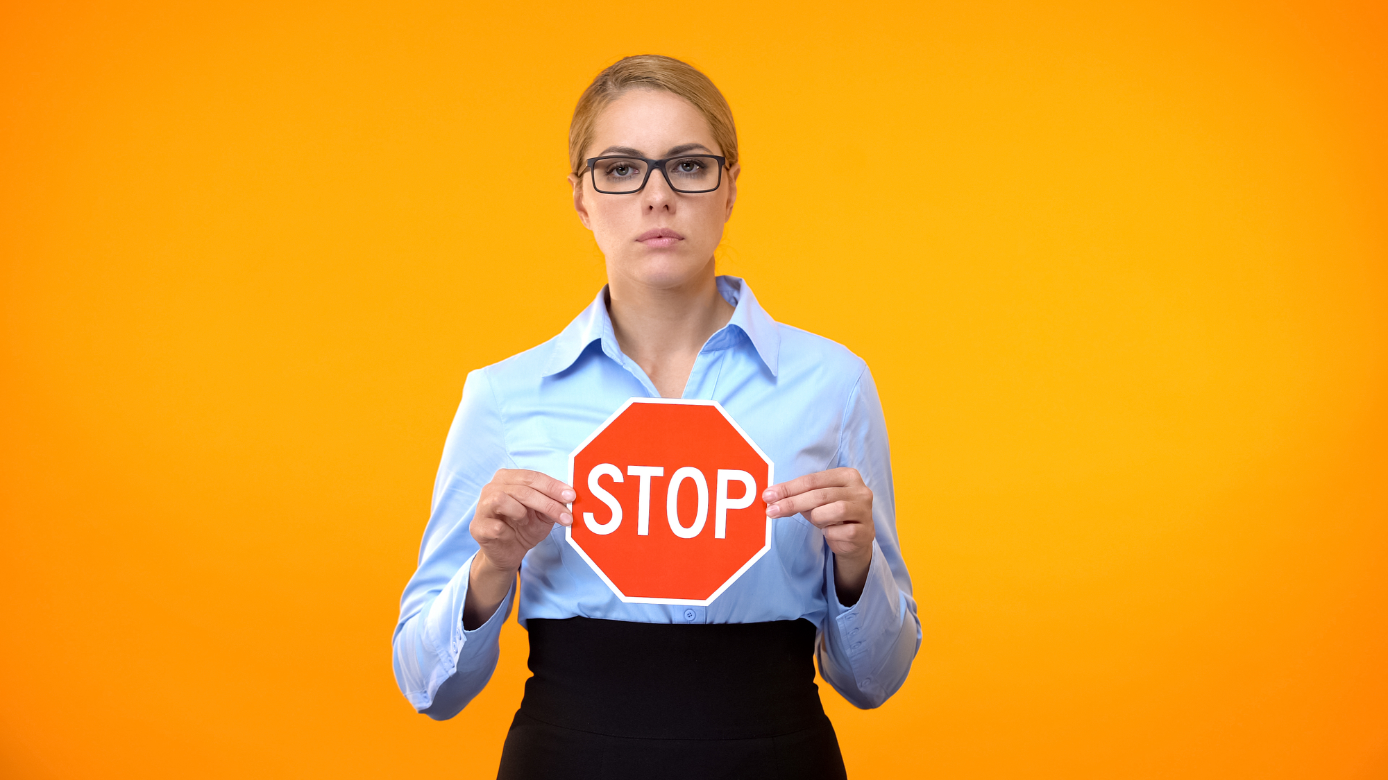 Sexual Harassment Lawyer Tampa, FL - Young business lady holding stop sign hands, sexual harassment at work, protest