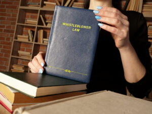 Whistleblower Retaliation Lawyer Tampa, FL - Attorney holds WHISTLEBLOWER LAW book. As a whistleblower you'